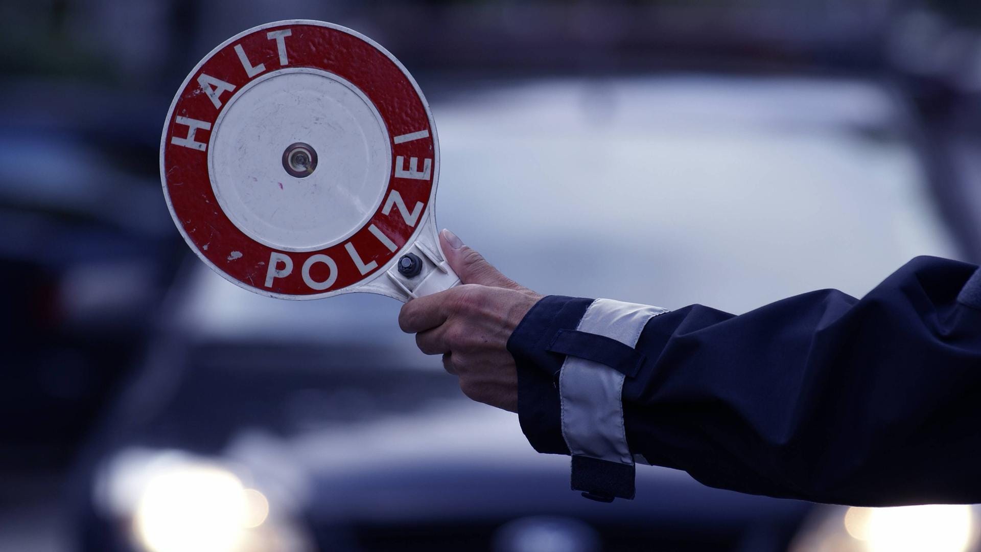 Ein Polizist hält eine Kelle mit der Aufschrift "Halt, Polizei" (Symbolbild): In Nürnberg wurde ein betrunkener und verkleideter Autofahrer erwischt. Ein Polizist hält eine Kelle mit der Aufschrift "Halt, Polizei" (Symbolbild): In Nürnberg wurde ein betrunkener und verkleideter Autofahrer erwischt.