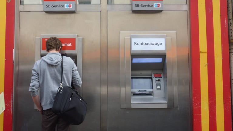 Ein Mann hebt Geld an einem Automaten ab: In Essen werden mehrere Geldautomaten der Sparkasse geschlossen.