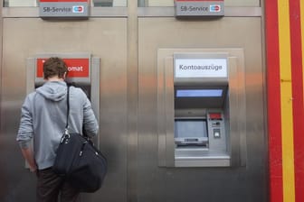 Ein Mann hebt Geld an einem Automaten ab: In Essen werden mehrere Geldautomaten der Sparkasse geschlossen.