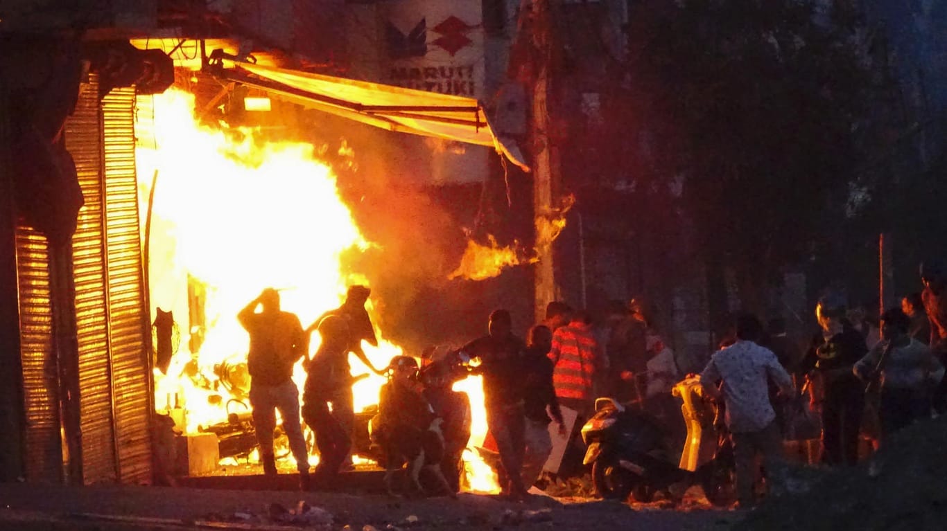 Ein Mob steckt einen Laden in Neu Delhi in Brand: Die Gewalt in Indien hielt am Dienstag trotz eines verhängten Versammlungsverbots an.