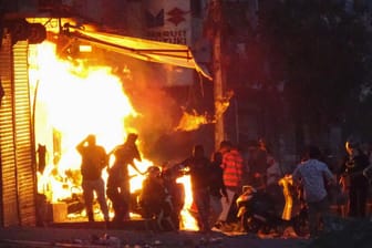 Ein Mob steckt einen Laden in Neu Delhi in Brand: Die Gewalt in Indien hielt am Dienstag trotz eines verhängten Versammlungsverbots an.