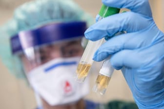 Eine Krankenschwester auf der Infektionsstation der Uniklinik Essen betrachtet zwei Abstrichröhrchen. In NRW ist erstmals ein Patient nachweislich an dem neuartigen Coronavirus erkrankt.