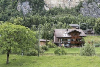 Ein Haus im Dorf Mitholz: Im Hintergrund ist die Felskante zu sehen, die entstand, als bei der Explosion von 1947 Teile des Berges einstürzten.