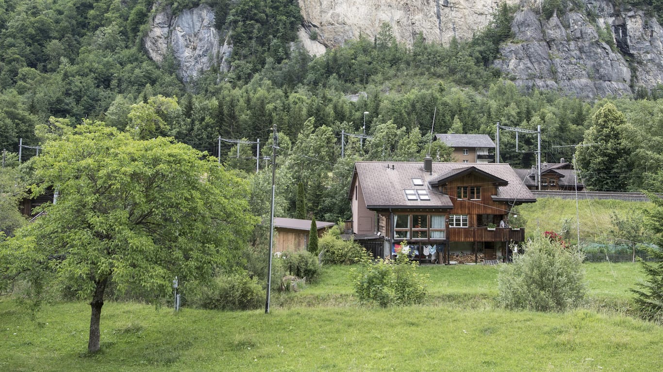 Ein Haus im Dorf Mitholz: Im Hintergrund ist die Felskante zu sehen, die entstand, als bei der Explosion von 1947 Teile des Berges einstürzten.