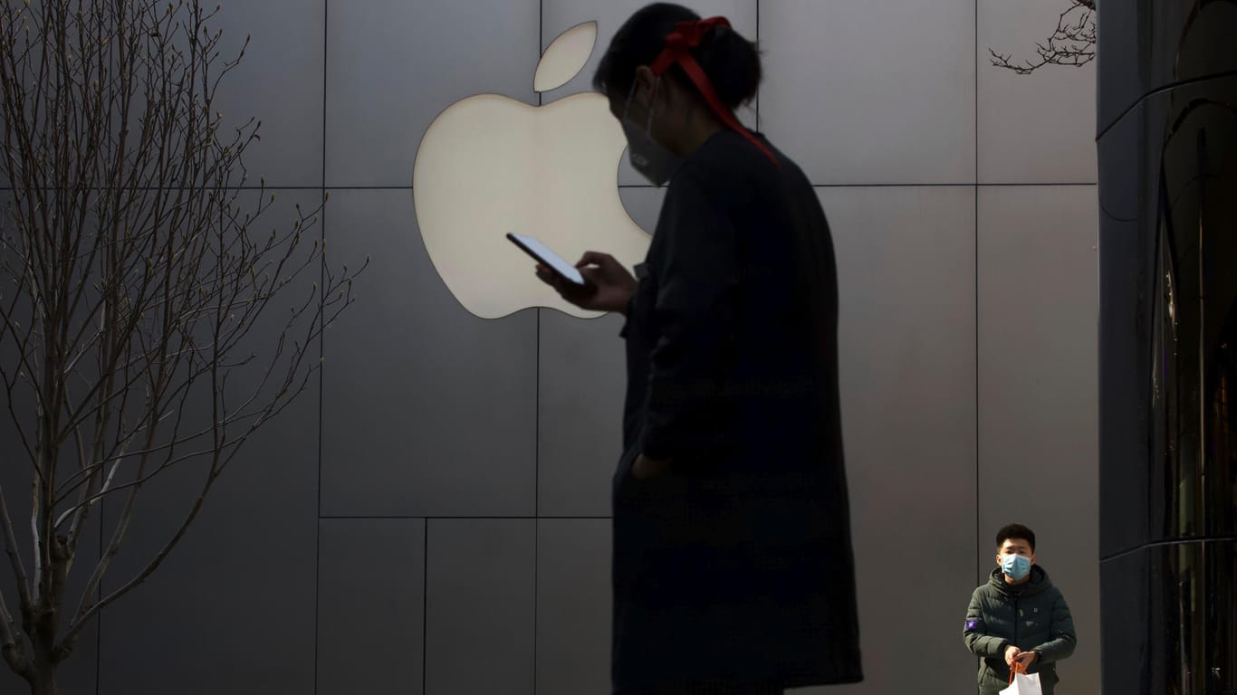 Mann mit Maske vor einem Apple-Logo: Der Corona-Ausbruch könnte den Zeitplan für das neue iPhone im Herbst gefährden