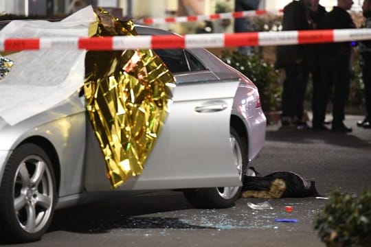 Ein Auto ist mit Thermofolie abgedeckt, neben dem Wagen liegen Glassplitter und eine Jacke.