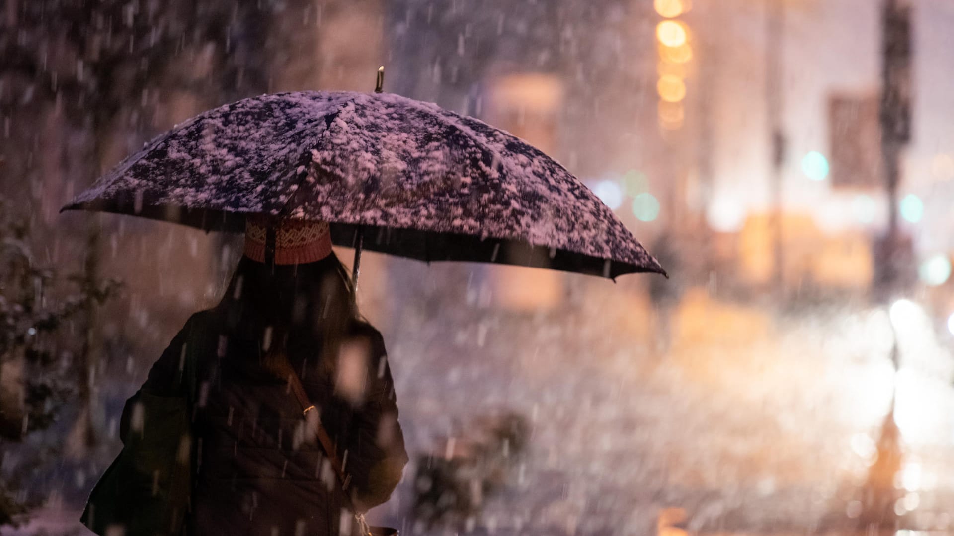 Eine Frau geht bei Schneefall auf dem Gehsteig: In Nürnberg hat es geschneit.