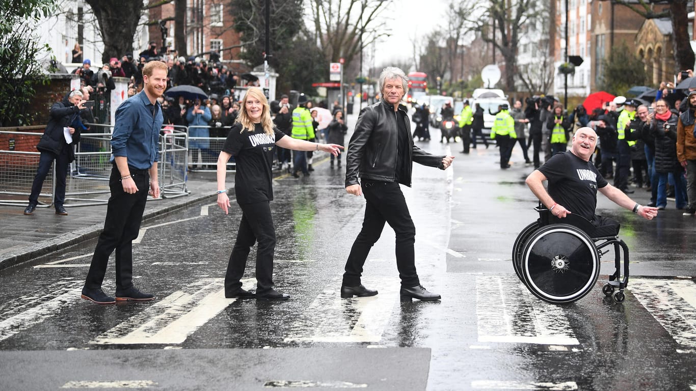 Prinz Harry und Jon Bon Jovi: Hier gehen sie gemeinsam mit Mitgliedern des Invictus-Games-Chors über den berühmten Zebrastreifen vor den Abbey-Road-Studios.