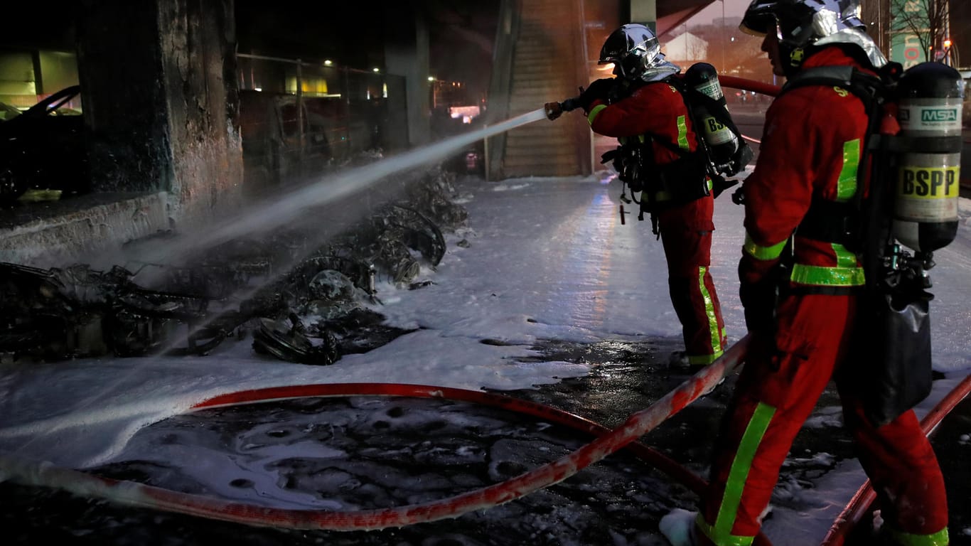 Feuerwehrleute löschen brennende Motorroller vor dem Gare de Lyon: In der Umgebung des Pariser Fernbahnhofs brannten nach Angaben der Behörden auch mehrere Autos. Feuerwehrleute löschen brennende Motorroller vor dem Gare de Lyon: In der Umgebung des Pariser Fernbahnhofs brannten nach Angaben der Behörden auch mehrere Autos.