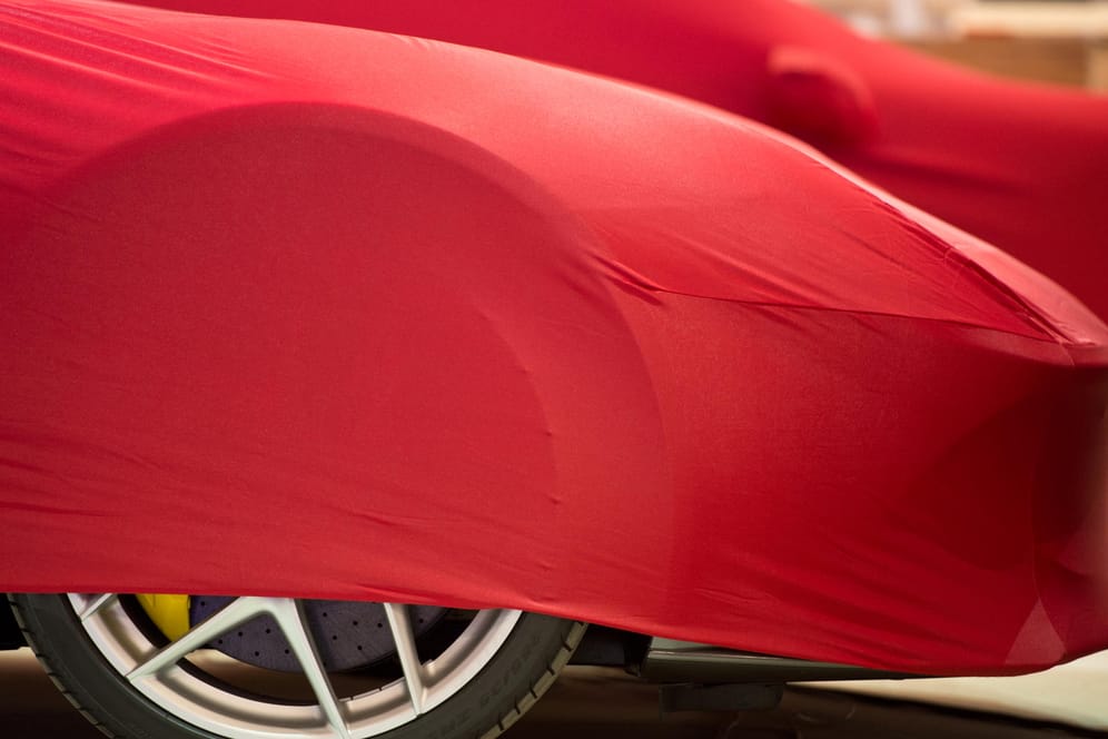 Noch abgedeckte Luxuswagen auf der IAA: Am 3. März wird voraussichtlich über den künftigen Standort für die Mobilitätsmesse entschieden.