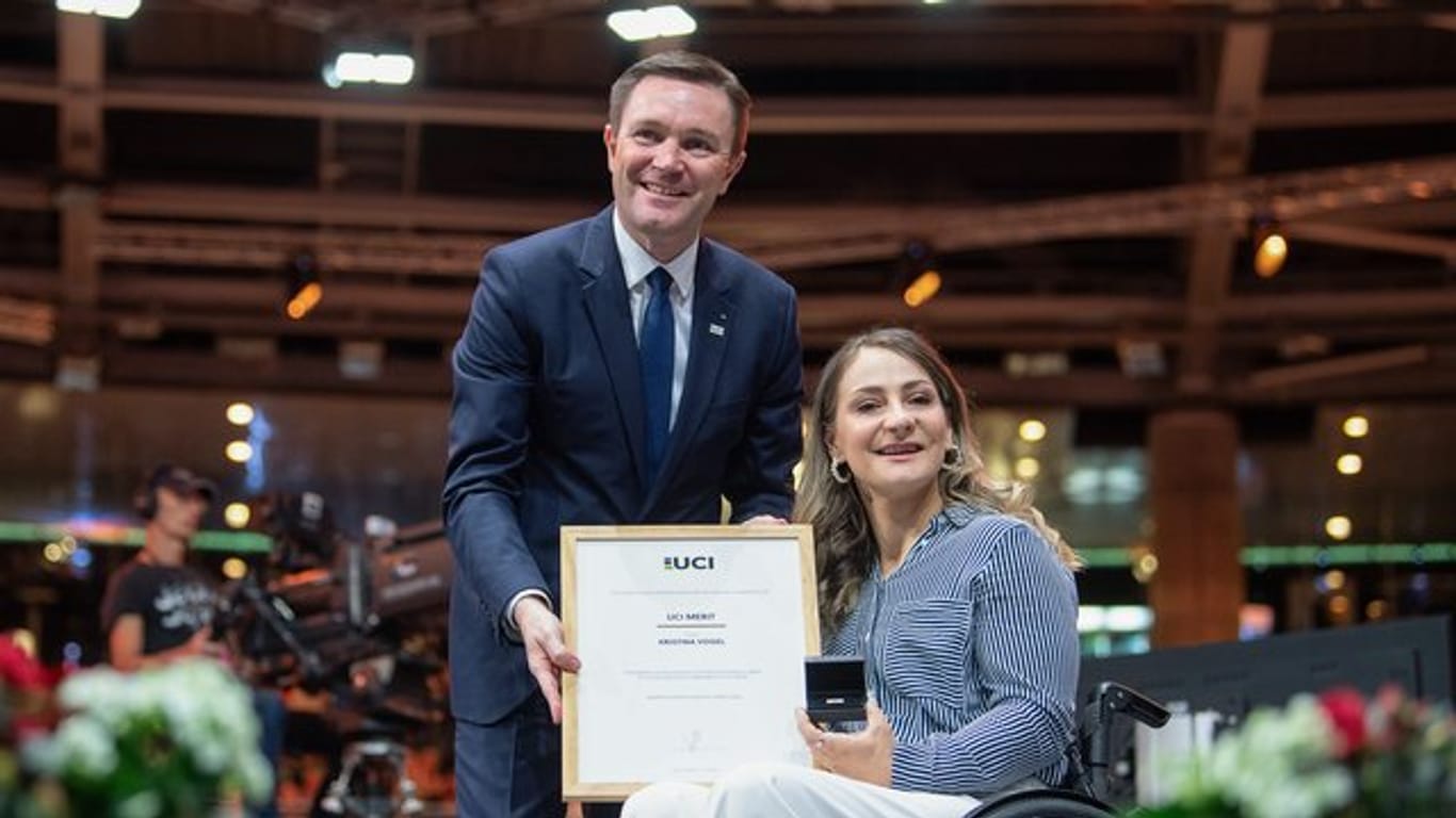 UCI-Präsident David Lappartient übergibt Kristina Vogel den Ehrenpreis.