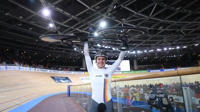 Emma Hinze stemmt nach ihrem Sieg im Keirin ihr Rad.