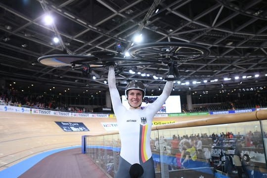 Emma Hinze stemmt nach ihrem Sieg im Keirin ihr Rad.