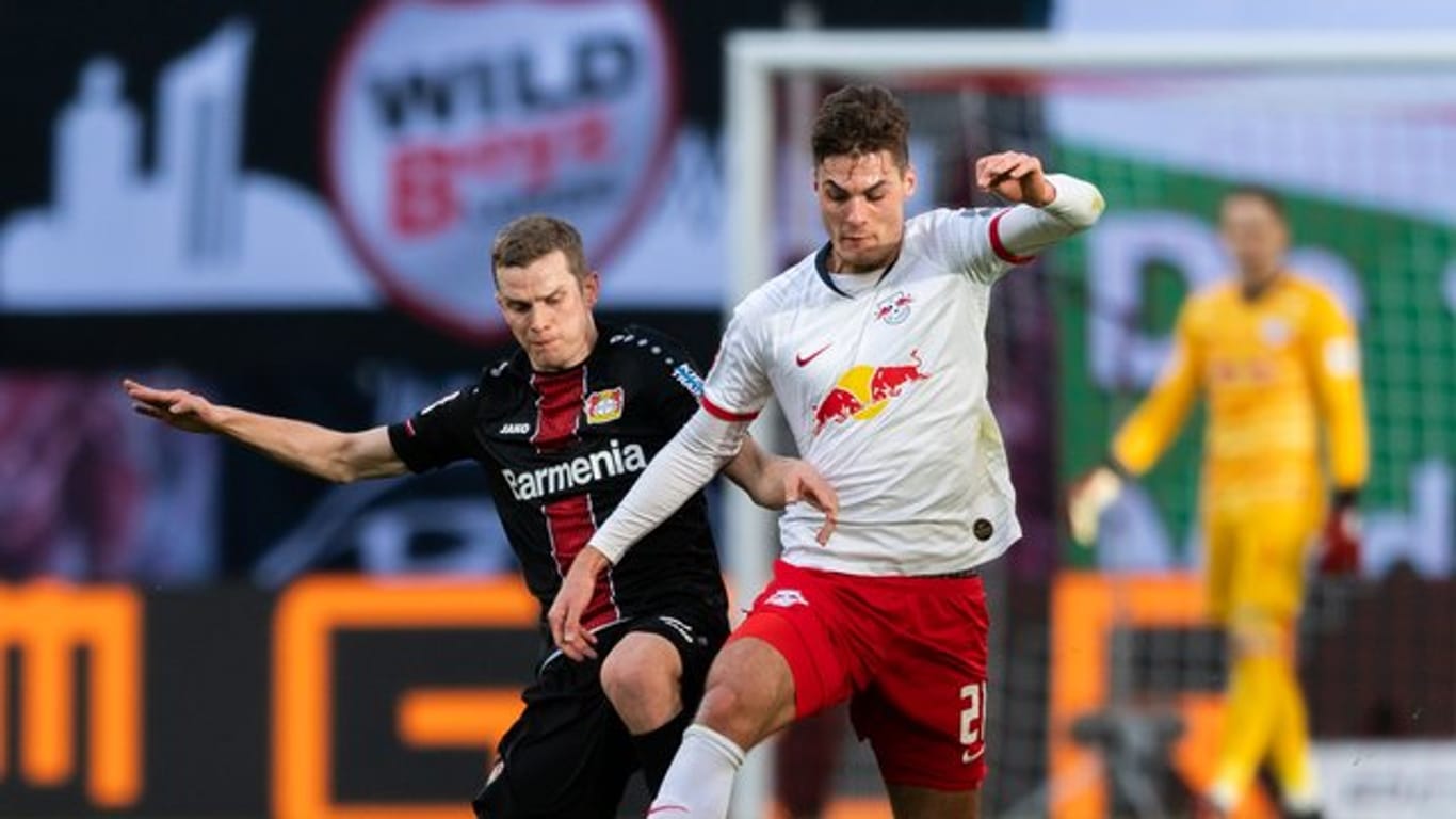 Leverkusens Sven Bender (l) geht gegen Leipzigs Patrik Schick von hinten in den Zweikampf.