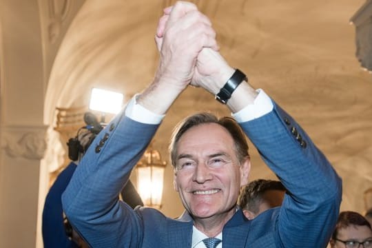 Burkhard Jung (SPD), der wiedergewählte Oberbürgermeister von Leipzig, jubelt beim Betreten des Rathauses.