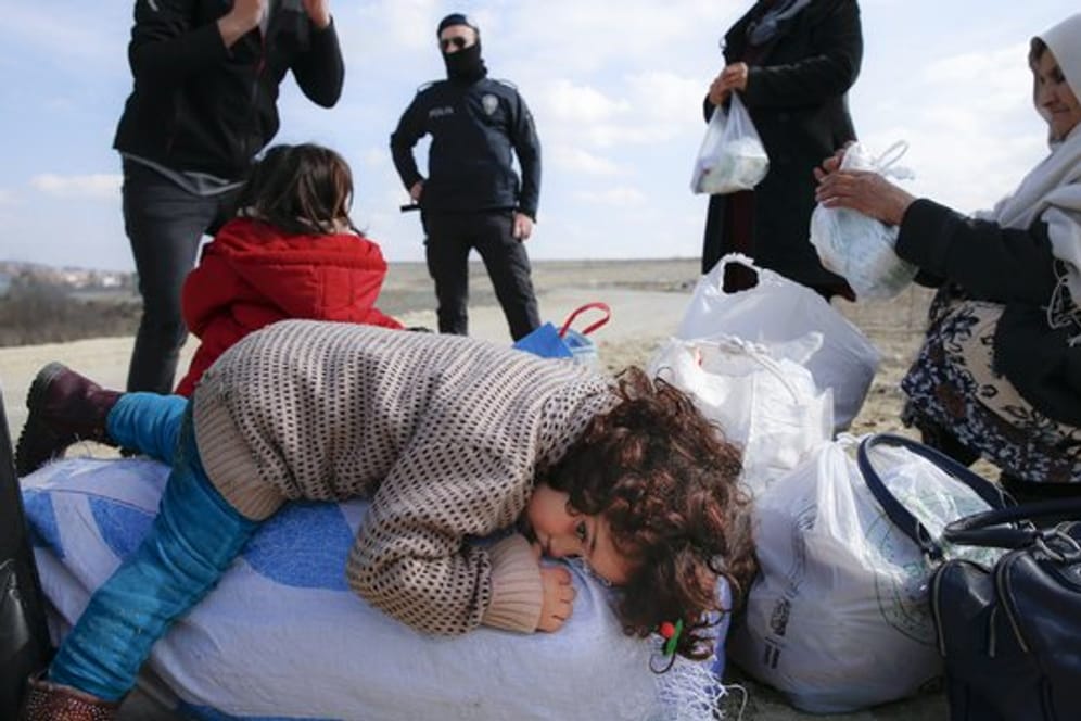 In der Nähe des Grenzübergangs Pazarakule ruht sich ein Kind auf einem Sack mit Habseligkeiten aus.