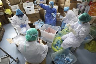 Krankenschwestern montieren Gesichtsmasken für Infizierte.