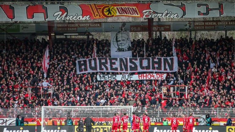 Union-Fans auf der Waldseite zeigen Banner mit beleidigendem Schriftzug und dem Abbild von Dietmar Hopp: Das Spiel gegen Wolfsburg wäre fast abgebrochen worden.