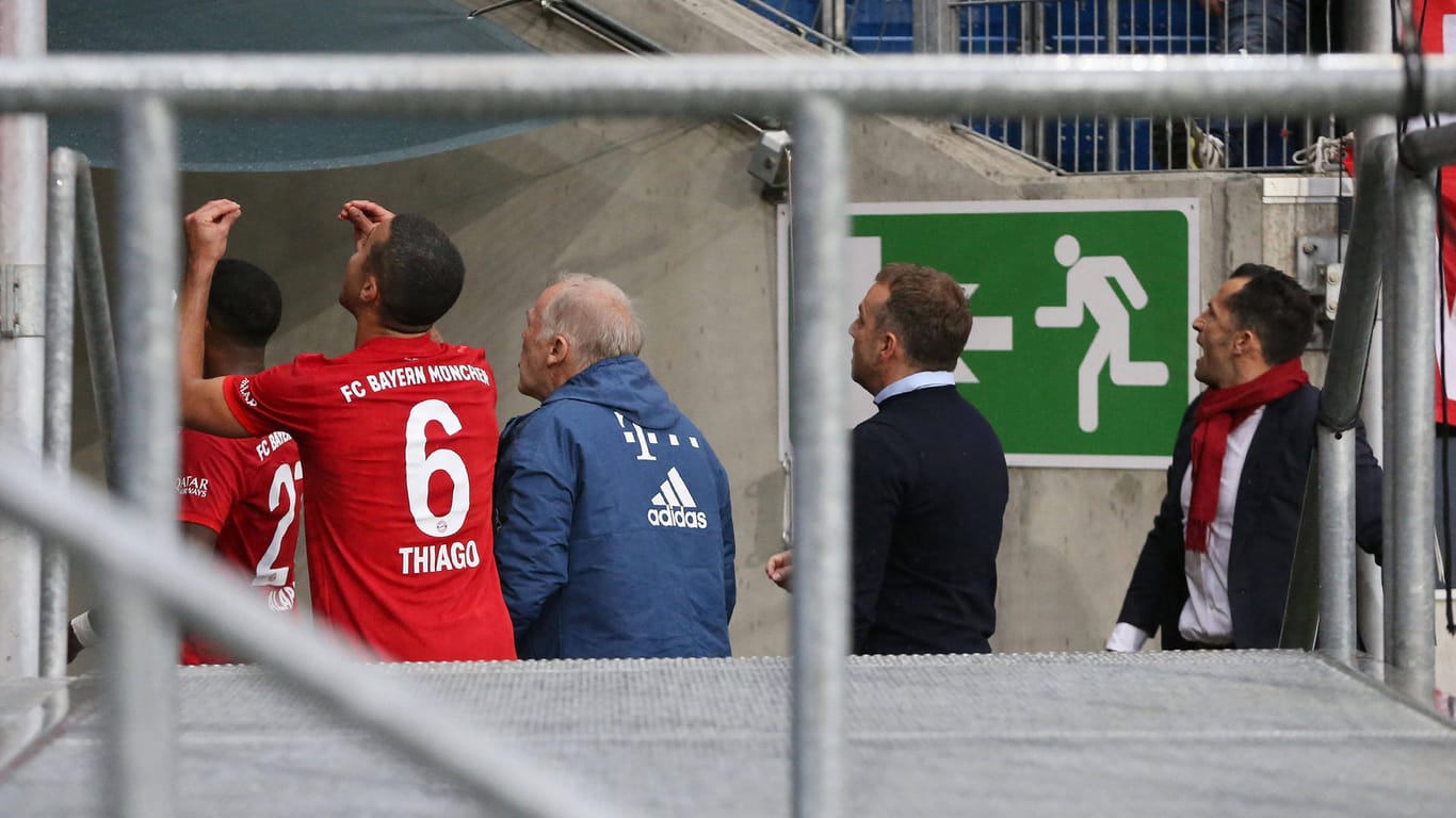 Bayern-Profi Thiago Alcantara gestikuliert zur Fankurve: Nach einer Unterbrechung verlassen die Spieler den Platz.