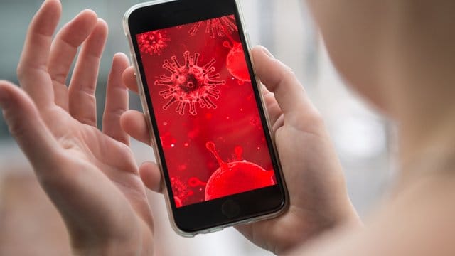 Virus-Darstellung auf einem Smartphone: Bei Nachrichten und Seiten, die angeblich mit dem neuartigen Coronavirus zu tun haben, sollte man äußerste Vorsicht walten lassen.