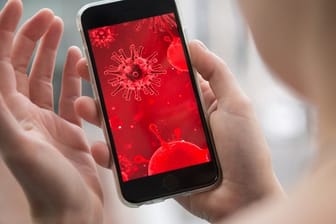 Virus-Darstellung auf einem Smartphone: Bei Nachrichten und Seiten, die angeblich mit dem neuartigen Coronavirus zu tun haben, sollte man äußerste Vorsicht walten lassen.