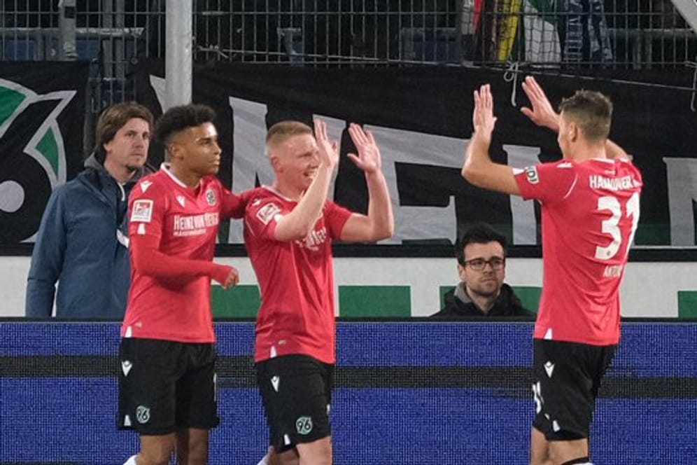 Hannovers Philipp Ochs (M) bejubelt sein Tor zum 2:1 gegen Holstein Kiel mit Linton Maina und Waldemar Anton (r).