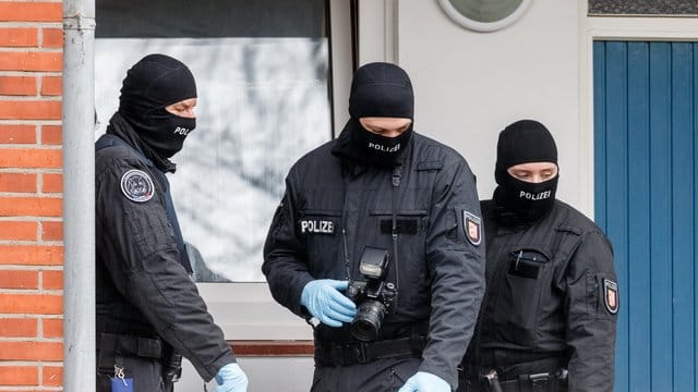 SEK-Beamte stehen während einer Razzia vor einer Wohnung in Bad Segeberg. SEK-Beamte stehen während einer Razzia vor einer Wohnung in Bad Segeberg.