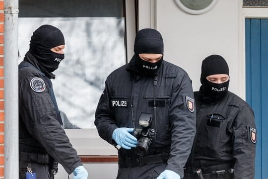 SEK-Beamte stehen während einer Razzia vor einer Wohnung in Bad Segeberg.