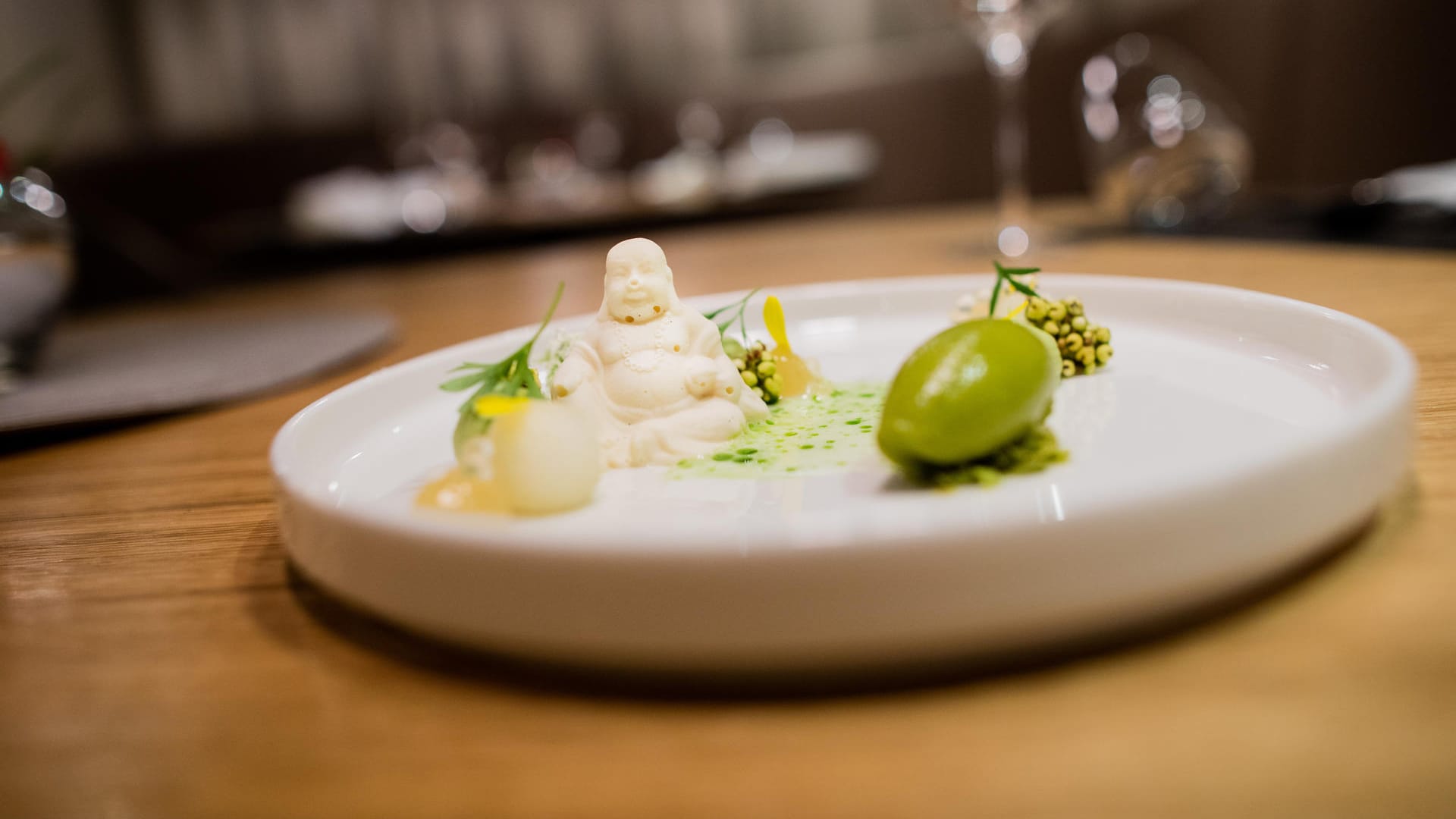 Neues Ein-Stern-Restaurant in Düsseldorf: Das Lokal "Setzkasten" serviert ein außergewöhnliches Dessert, das einen Buddha aus Stickyreis-Mousse, asiatische Pandancreme und Thaibasilikumsorbet beinhaltet.