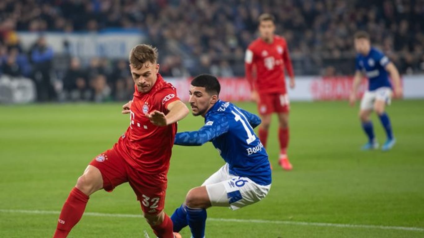 Bayerns Matchwinner Joshua Kimmich (l) setzt sich gegen Schalkes Nassim Boujellab durch.
