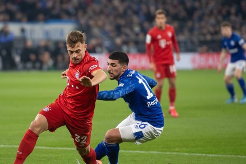 Bayerns Matchwinner Joshua Kimmich (l) setzt sich gegen Schalkes Nassim Boujellab durch.
