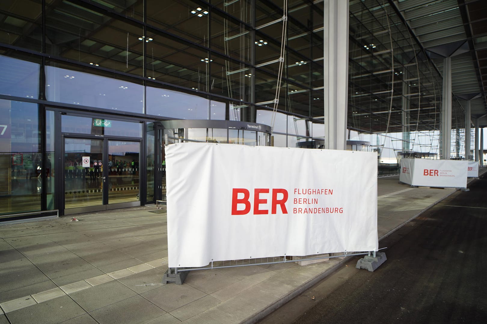 Ein Banner vor dem neuen Hauptstadtflughafen BER: Laut Einschätzung der Lufthansa ist die Anbindung des Flughafens an den öffentlichen Nahverkehr noch nicht ausreichend.