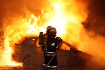 Einsatzkräfte löschen ein brennendes Auto in Berlin: Am Donnerstag sind in Berlin-Neukölln zwei Autos durch Feuer beschädigt worden.