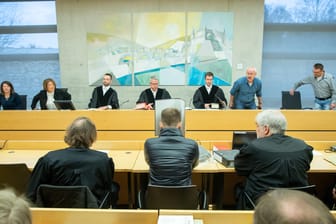 Prozess in Würzburg: Ein wegen Missbrauchs von Kindern angeklagter Logopäde sitzt im Sitzungssaal im Landgericht zwischen seinen Verteidigern.