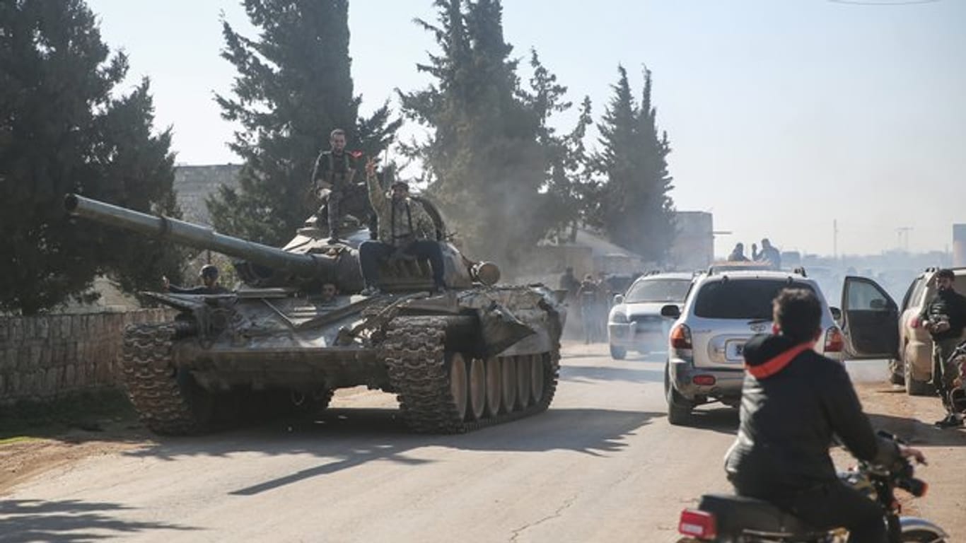 Kämpfer der oppositionellen Nationalen Befreiungsfront sind mit einem Panzer in der Region Idlib unterwegs (Archiv).