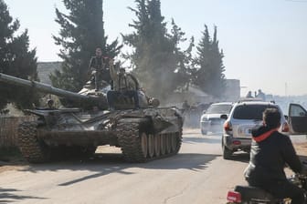 Kämpfer der oppositionellen Nationalen Befreiungsfront sind mit einem Panzer in der Region Idlib unterwegs (Archiv).