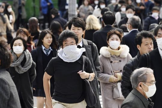 Wegen des Coronavirus tragen viele Passanten in Tokio Mundschutz.