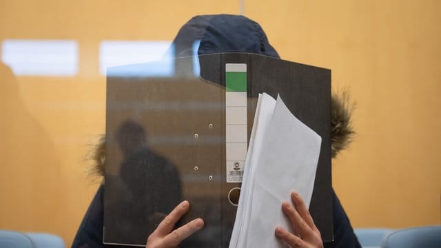 Die Angeklagte verbirgt im Düsseldorfer Oberlandesgericht ihr Gesicht hinter einem Aktenordner. Die Angeklagte verbirgt im Düsseldorfer Oberlandesgericht ihr Gesicht hinter einem Aktenordner.