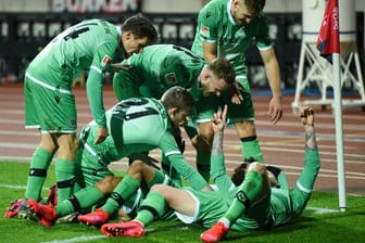Die Hannover Spieler feiern den 2:0-Treffer von Linton Maina (verdeckt).