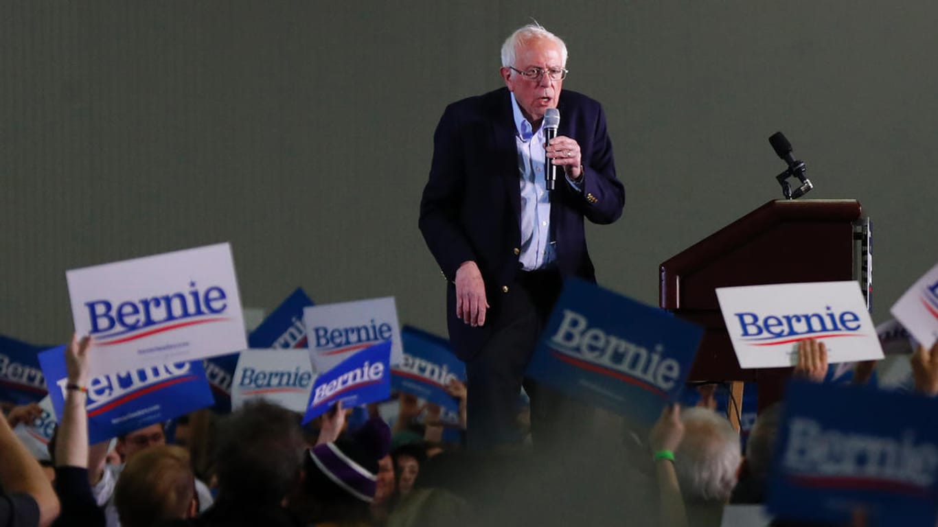 Eine Wahlveranstaltung von Bernie Sanders in den USA wird von einem Mann mit NS-Flagge gestört.