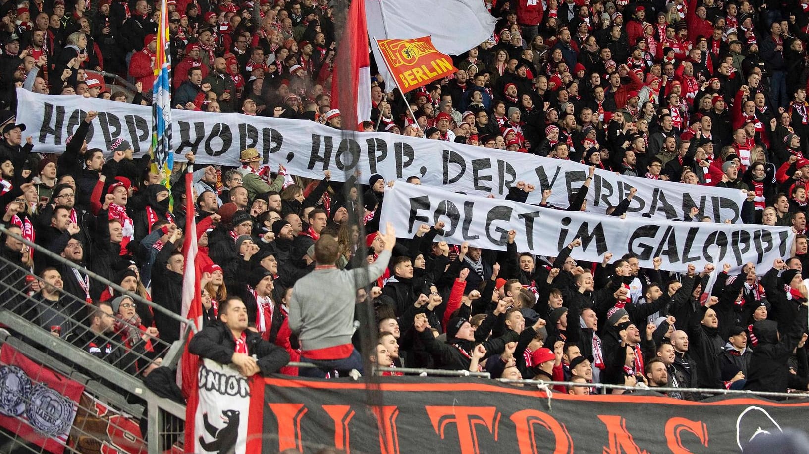 Ein kritisches Hopp-Plakat in der Fankurve von Union Berlin.