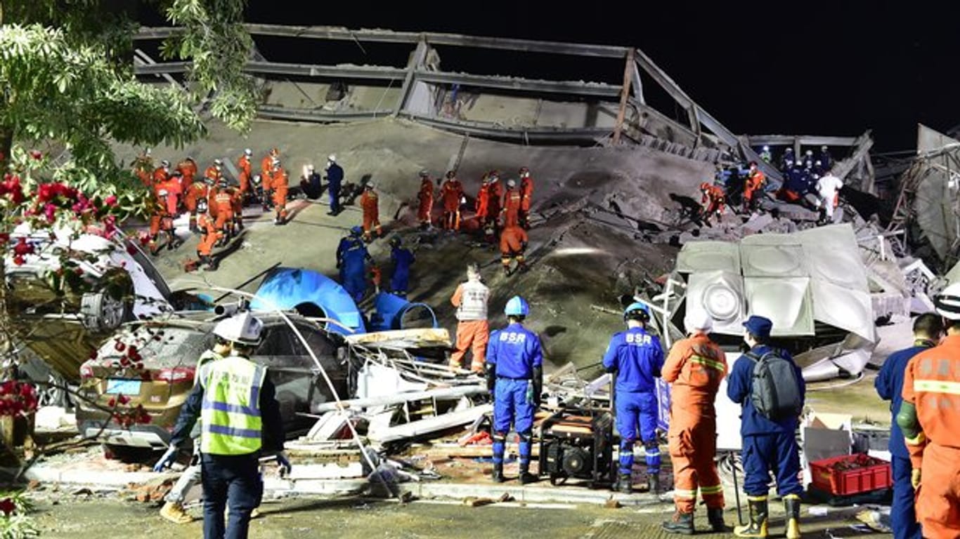 Rettungskräfte arbeiten an der Unfallstelle des eingestürzten Hotels.