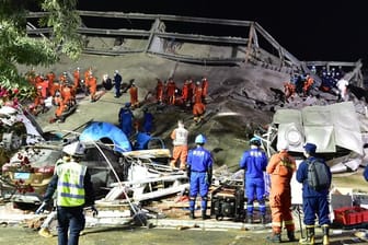 Rettungskräfte arbeiten an der Unfallstelle des eingestürzten Hotels.