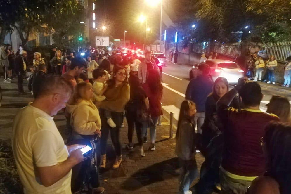 Menschen stehen in der Stadt Funchal auf der Straße: Anwohner und Urlauber haben sich wegen den Beben aus den Häusern begeben.