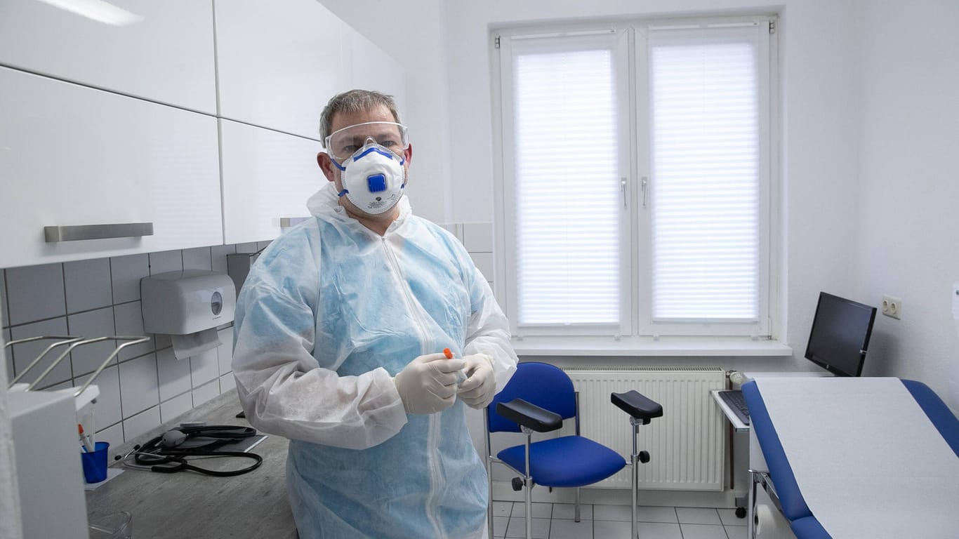 Ein Hausarzt in Schutzkleidung: So wie dieser Arzt, sind im März 2020 in Deutschland nur wenige Arztpraxen mit Schutzkleidung versorgt.