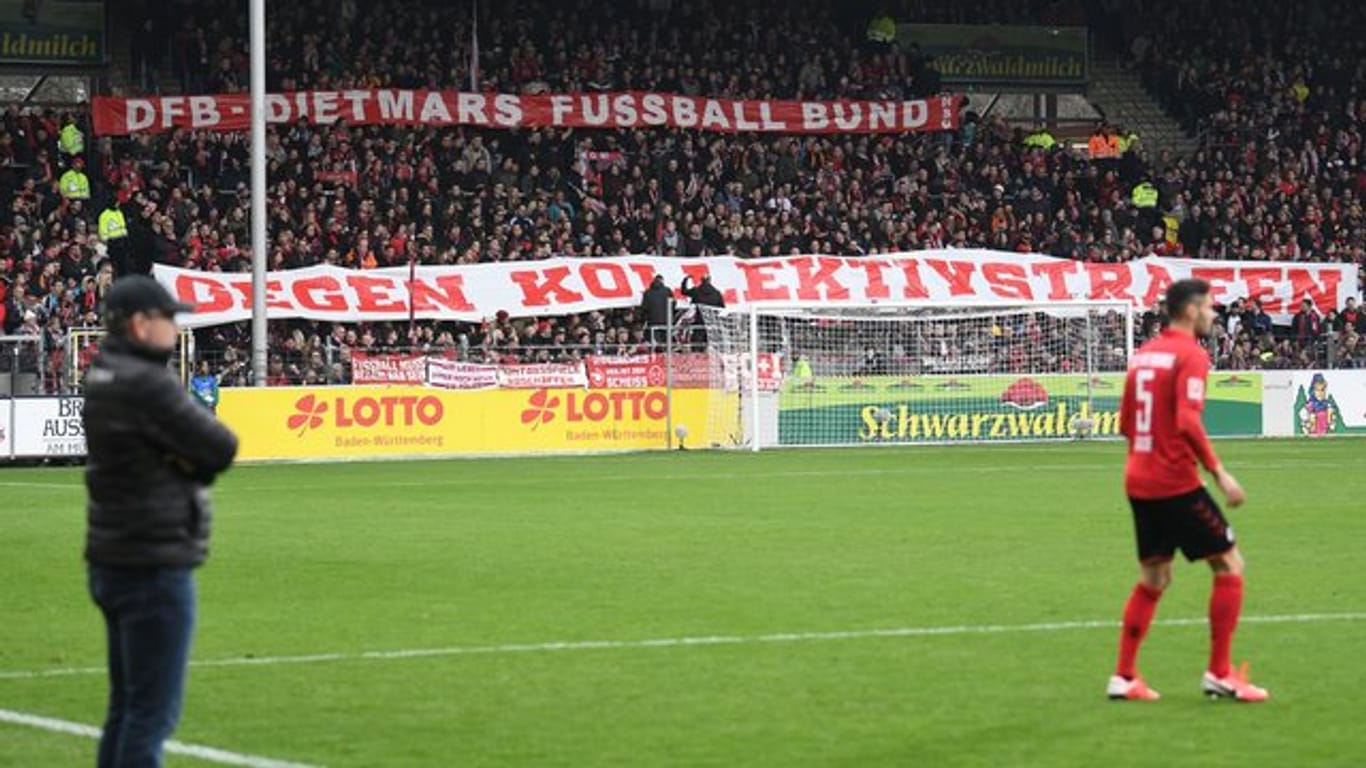 Freiburger Fans halten Banner mit der Aufschrift "DFB - Dietmars Fussball Bund gegen Kollektivstrafen" in die Höhe.
