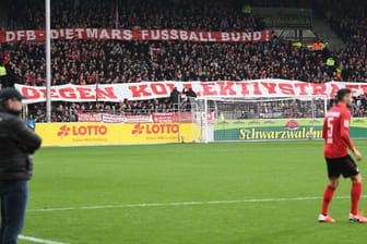 Freiburger Fans halten Banner mit der Aufschrift "DFB - Dietmars Fussball Bund gegen Kollektivstrafen" in die Höhe.