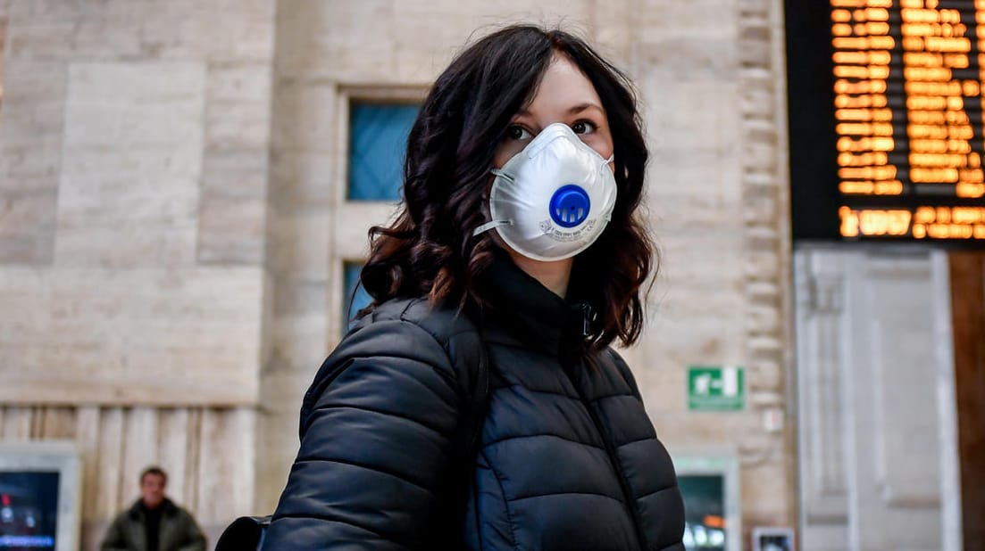 Eine Reisende mit Mundschutz am Mailänder Hauptbahnhof: Zur Eindämmung des Coronavirus hat Italien drastische Maßnahmen erlassen.