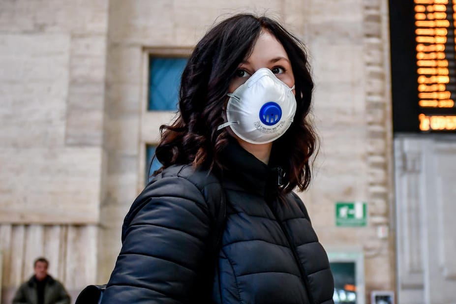 Eine Reisende mit Mundschutz am Mailänder Hauptbahnhof: Zur Eindämmung des Coronavirus hat Italien drastische Maßnahmen erlassen.