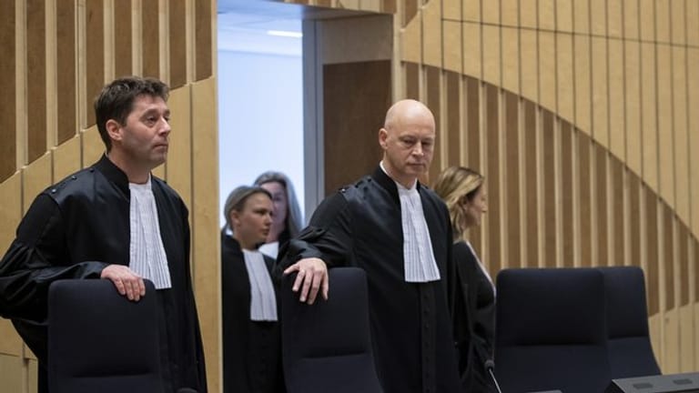 Der Vorsitzende Richter, Hendrik Steenhuis (r), und Richter Dagmar Koster (l) nehmen im Gerichtssaal ihre Plätze ein.
